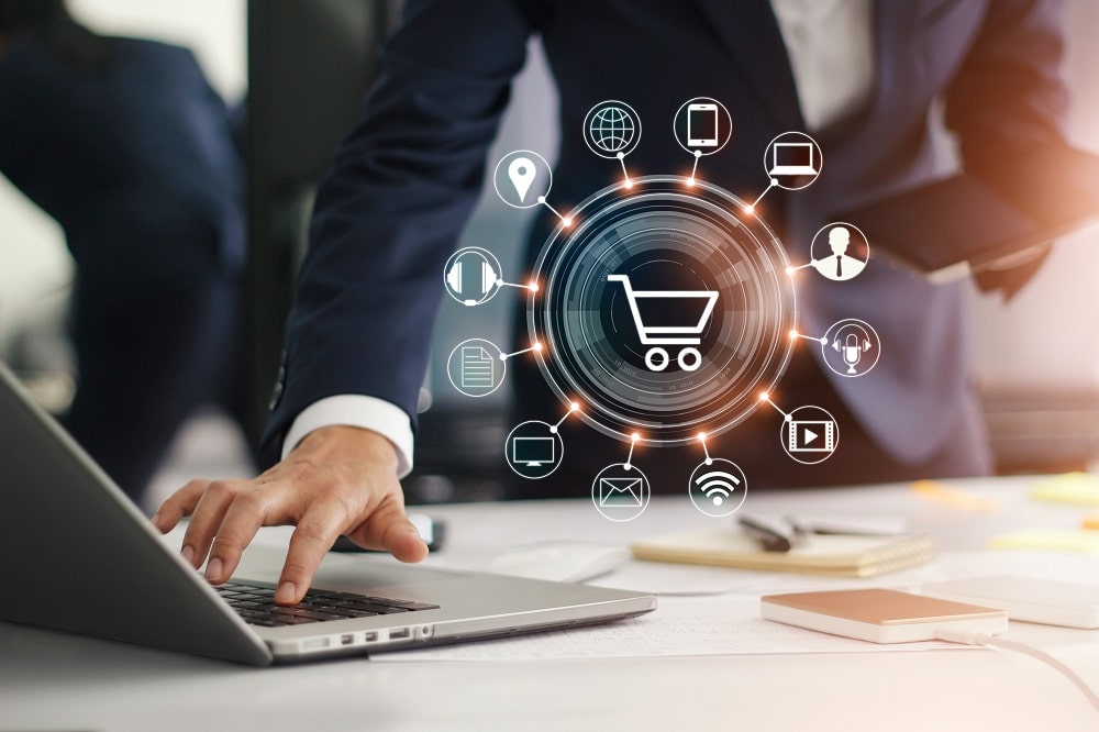 man typing on computer with shopping cart visualization