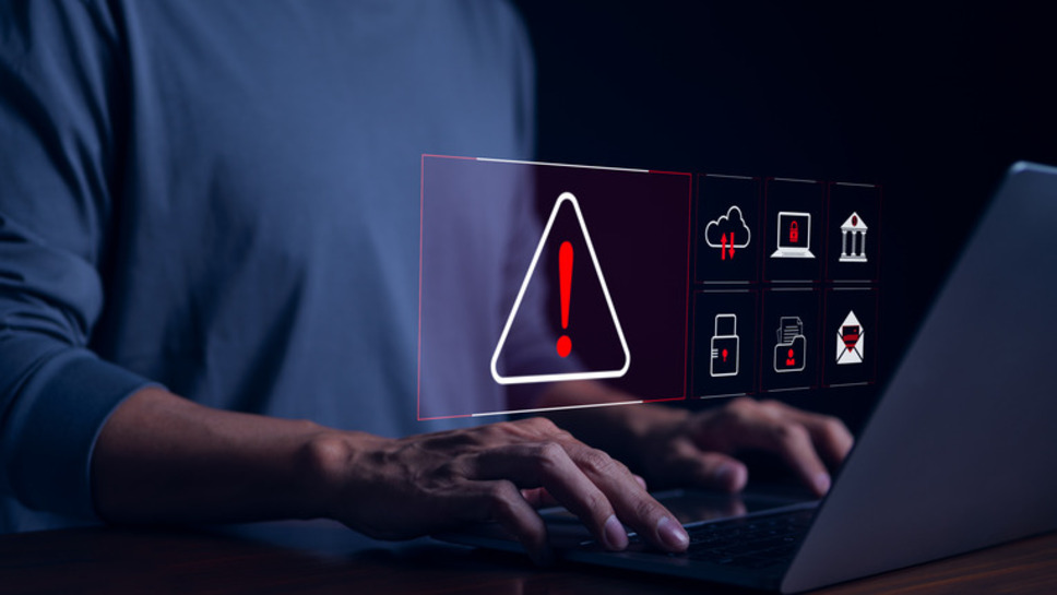 Person using laptop with a security alert on screen, emphasizing need for secure websites through successful web development