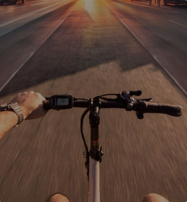 POV of cyclist riding an ebike on open road, showcasing a built-in digital display and ergonomic handlebars