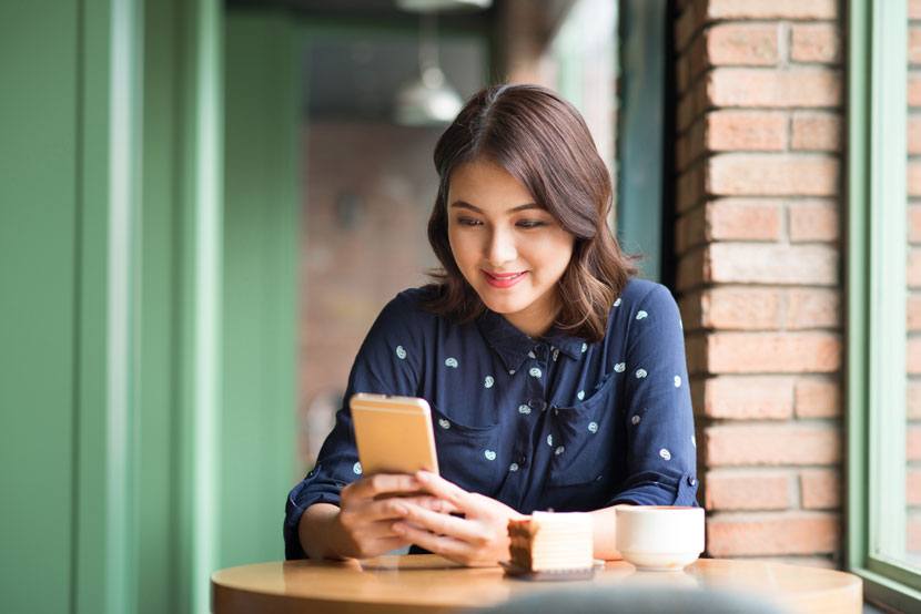 girl looking at her phone at a coffee shop