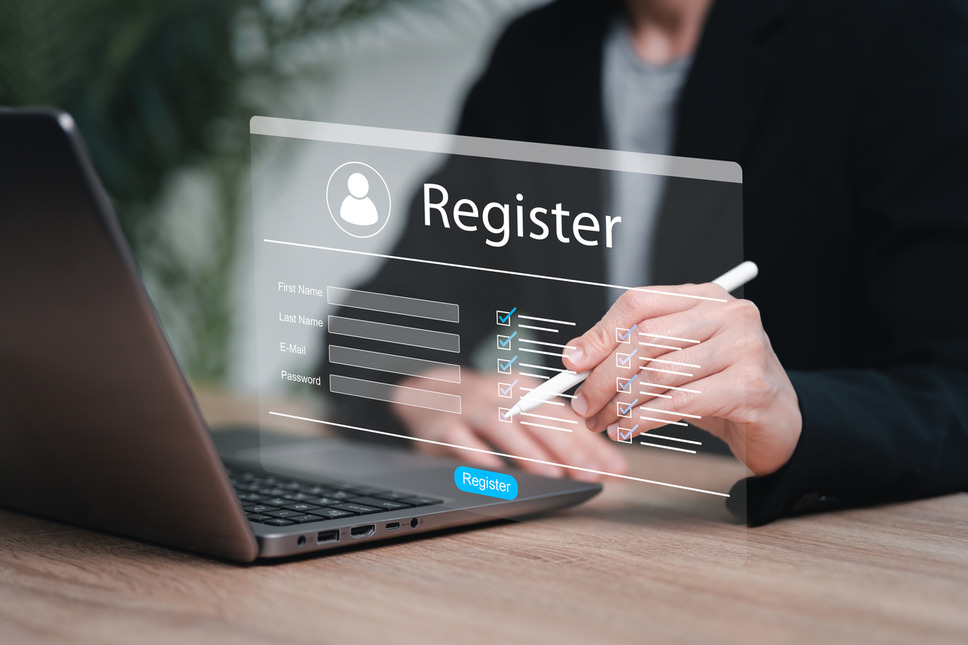 Person completing online registration form on laptop, depicting successful Sitecore agency services for association websites