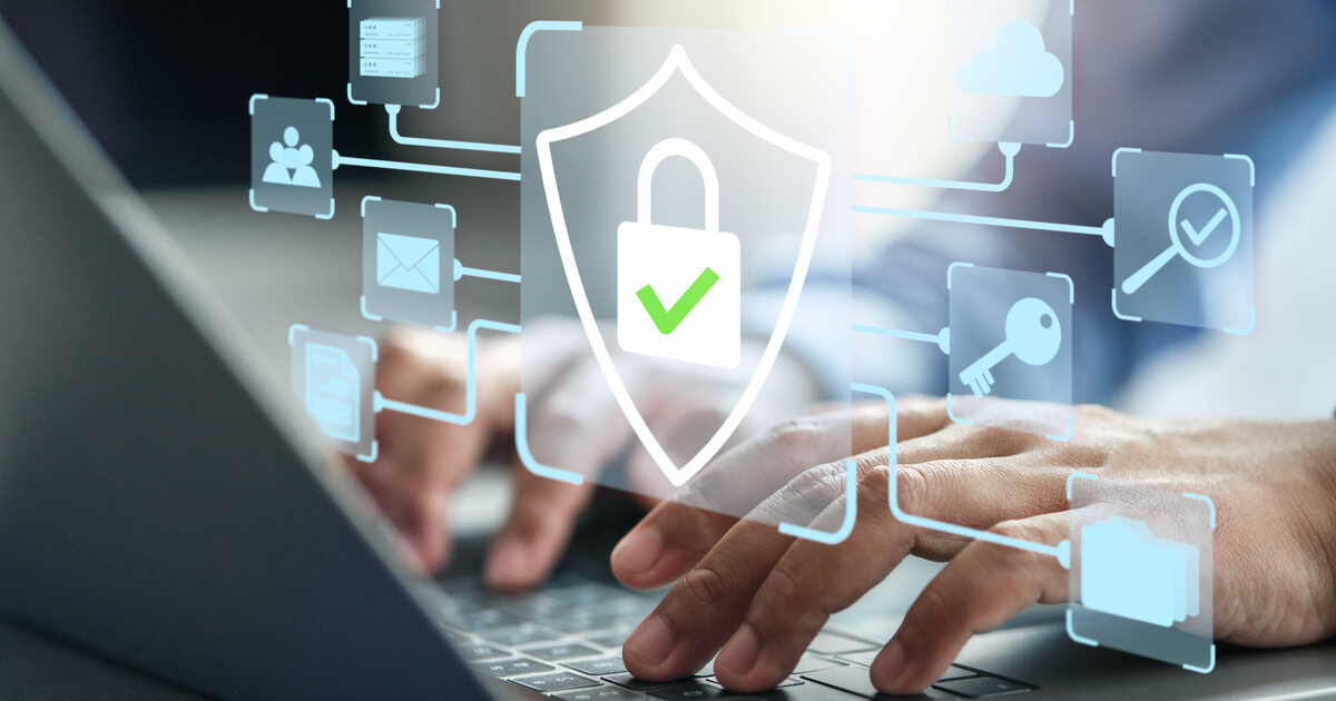 6 Steps to Reduce Data Privacy Risk Person typing on a laptop with cybersecurity icons, including a shield, lock, key and cloud, illustrating data privacy and digital security.