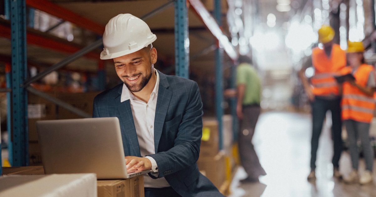 Professional using a laptop, viewing successful manufacturing website design examples using WordPress agency services