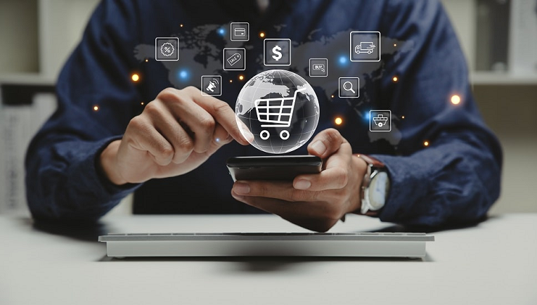 Businessman using smartphone with digital marketing and e-commerce icons hologram over laptop, concept of online business technology.