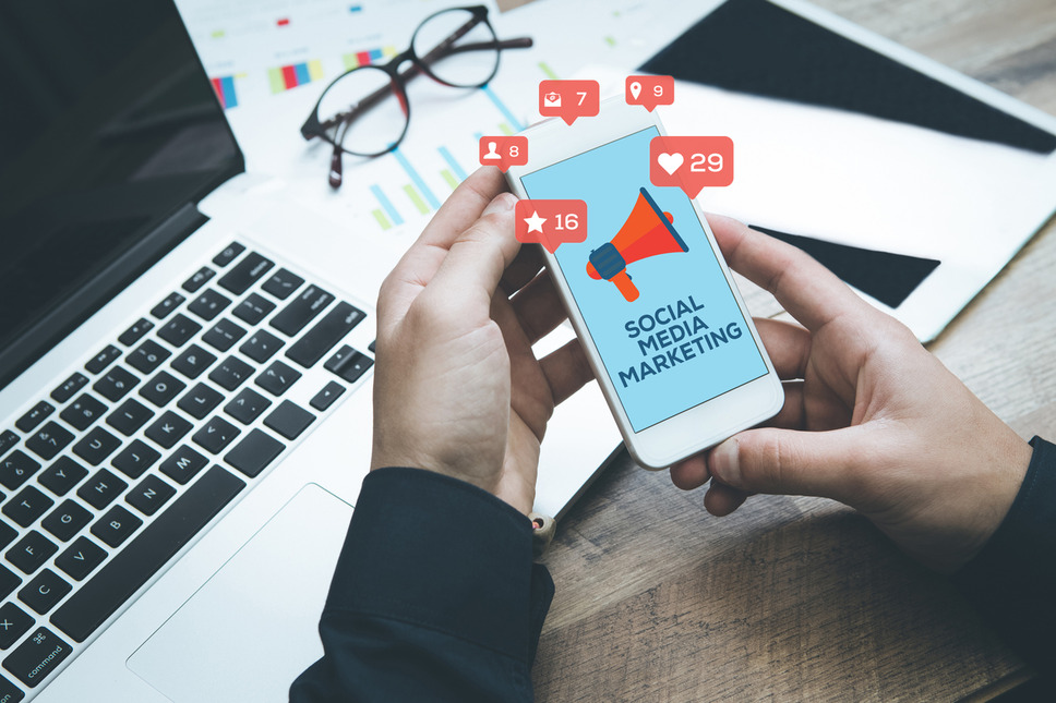 Marketer managing social media marketing overview and objectives using devices, symbolizing planning and digital engagement