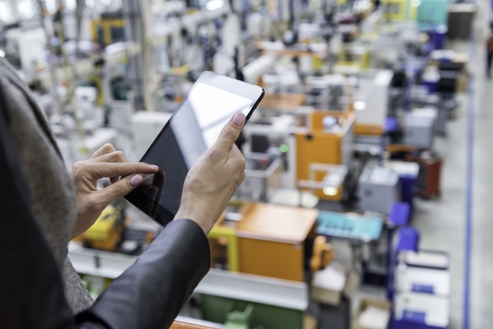 woman looking at inventory of warehouse on ipad