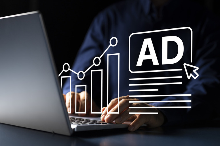 Person analyzing digital advertising performance metrics on a laptop, depicting business success with PPC ad strategies