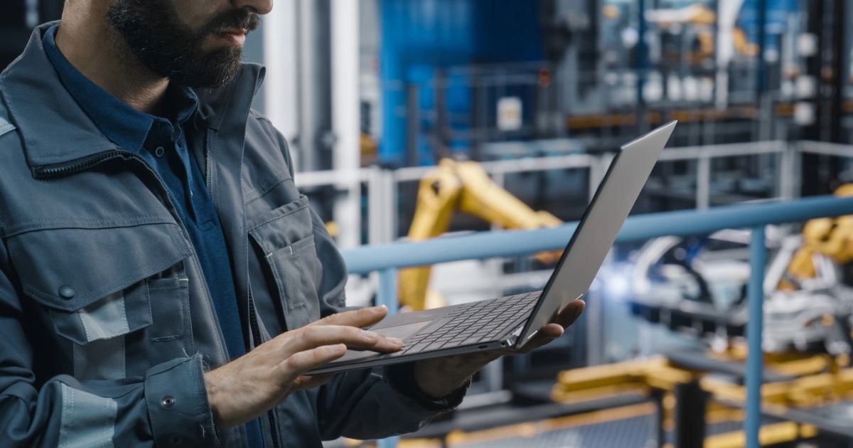 Worker using a laptop to browse a B2B website on BigCommerce, highlighting digital solutions for manufacturing industry