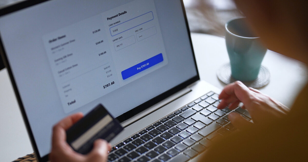 Person entering credit card details during an ecommerce checkout on a laptop, illustrating online payment and checkout optimization.
