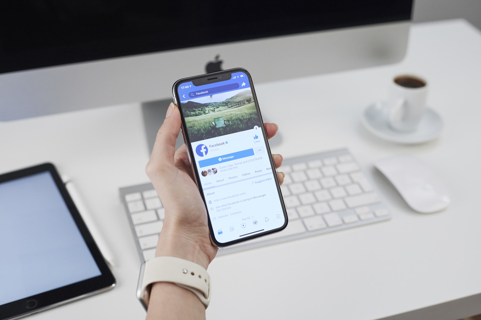 Professional using Facebook on a smartphone, depicting business success with digital agency social media marketing services