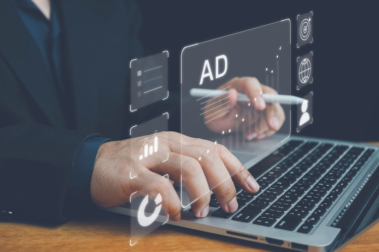 Business professional interacting with digital advertising interface using laptop, indicating success with Google Ads Auction