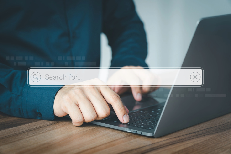 Person using laptop to type long-tail keywords into search bar, indicating business success with seo agency services
