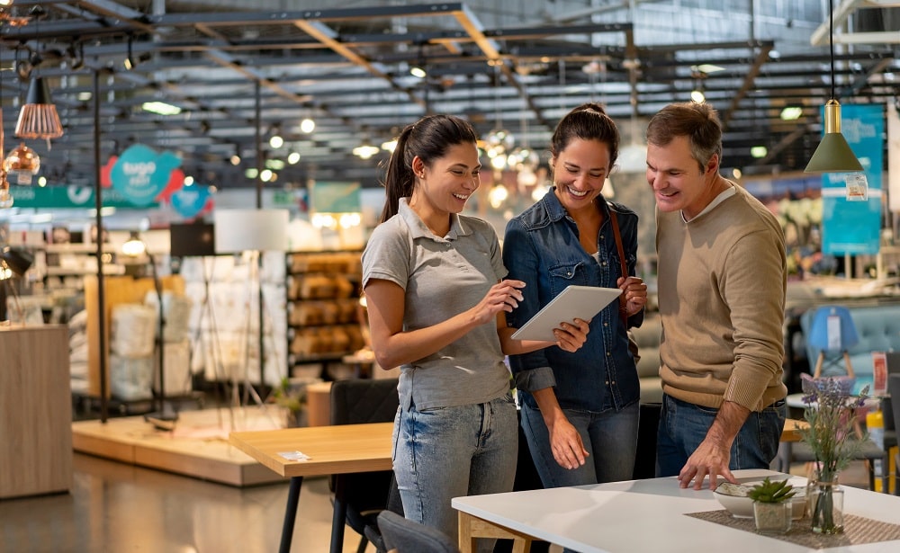 Couple buying furniture with sales lady and iPad