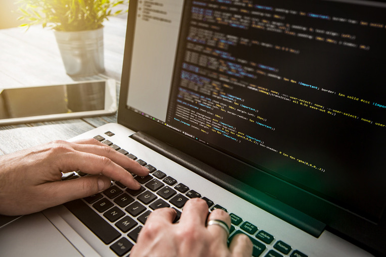 Sitecore certified agency developer coding on laptop, representing success with Sitecore training and certification process