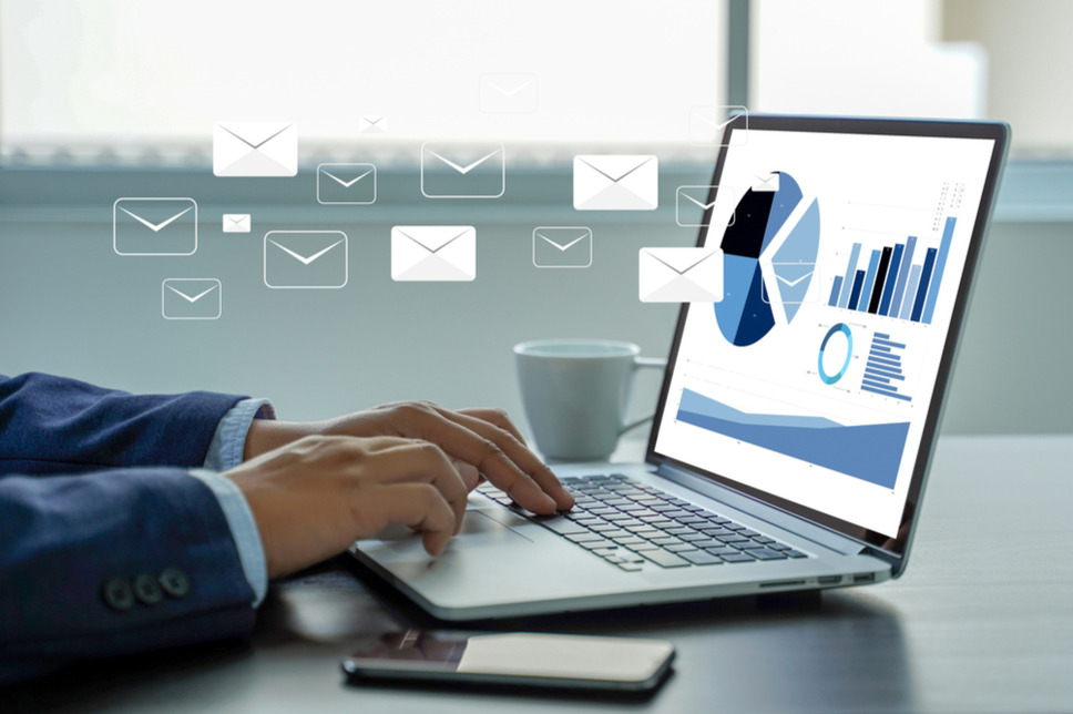 Businessperson analyzing email marketing campaign performance on a laptop, signifying success with digital marketing company