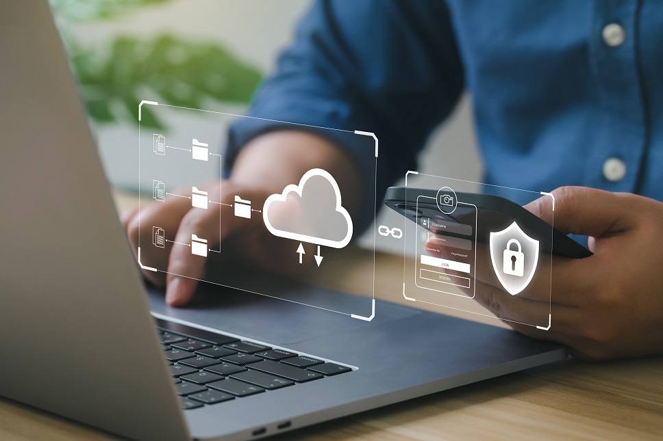 A person using a laptop with digital icons for cloud storage and security floating above the screen, symbolizing online data protection.