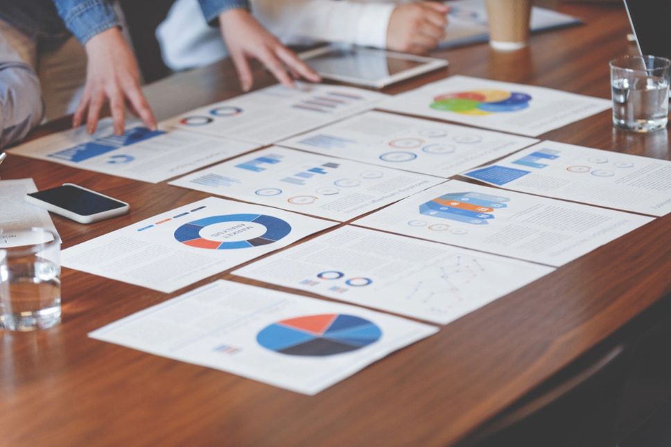 Agency strategists reviewing analytics report, analyzing how to calculate ROI in digital marketing and increase marketing ROI