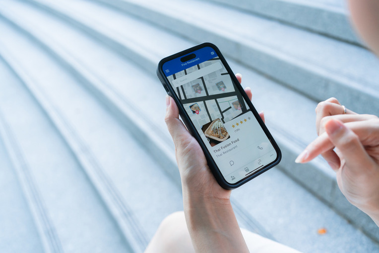 Person browsing a business profile on Google using a mobile device, displaying GBP success with digital marketing agency