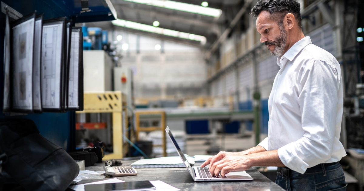 Manufacturer reviewing organic search performance on a laptop, depicting business success with SEO agency services for B2B