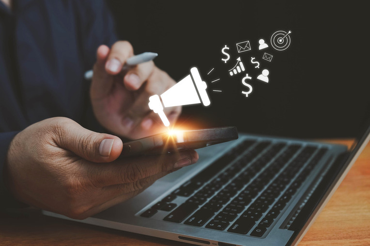 Business professional using smartphone displaying social media advertising icons, signifying success digital marketing agency