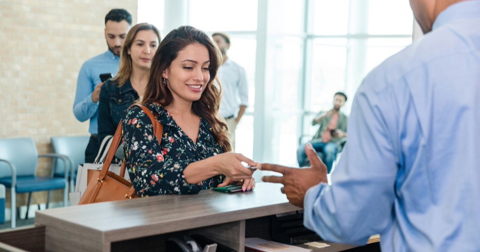 Customer at bank service desk, symbolizing improved visibility and engagement with local SEO for financial services and banks