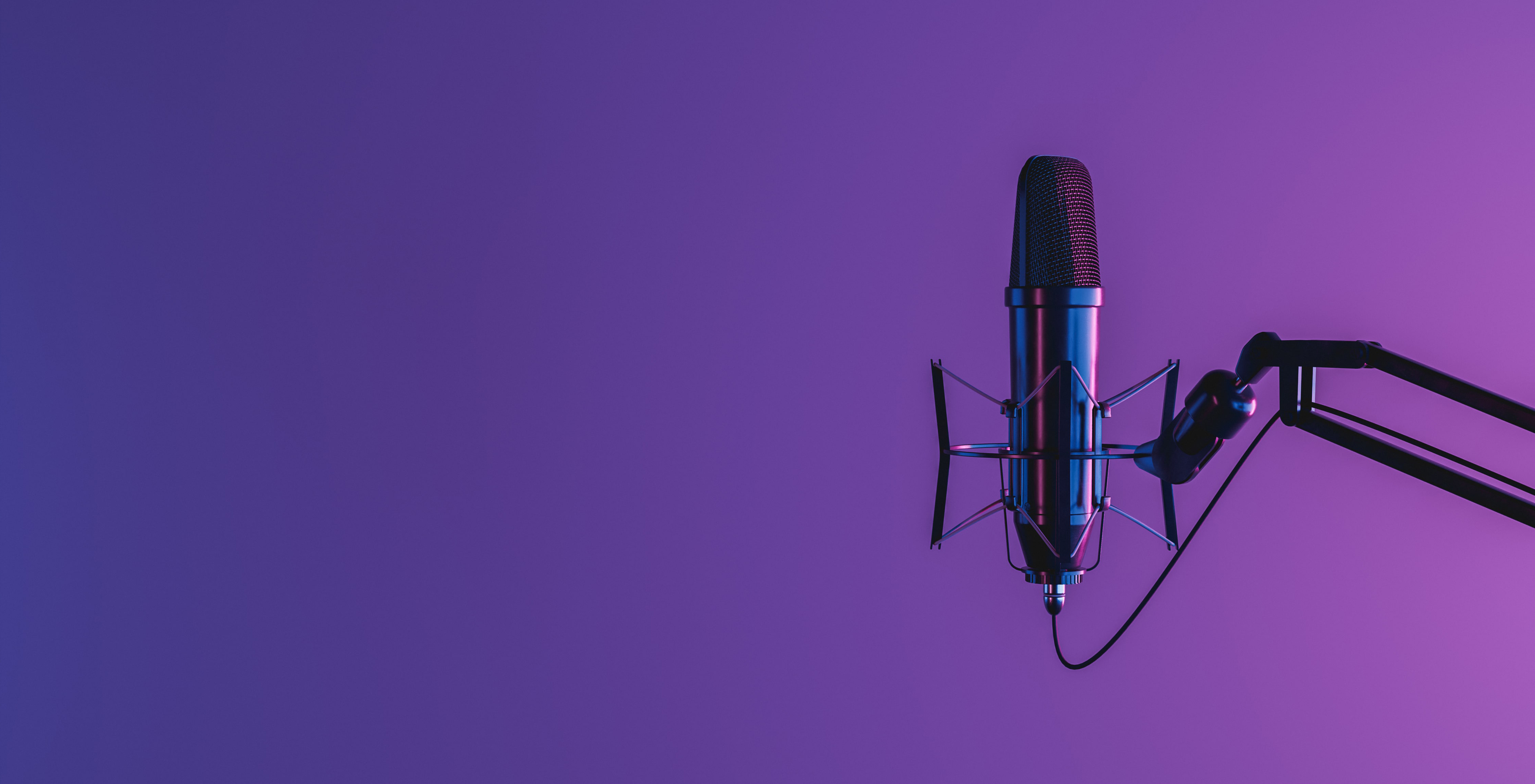 Podcasting microphone in front of a purple gradient background
