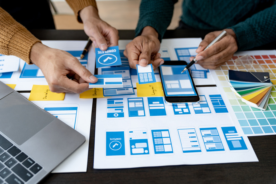 UX designers collaborating using paper prototypes, demonstrating success with Sitefinity website design agency services