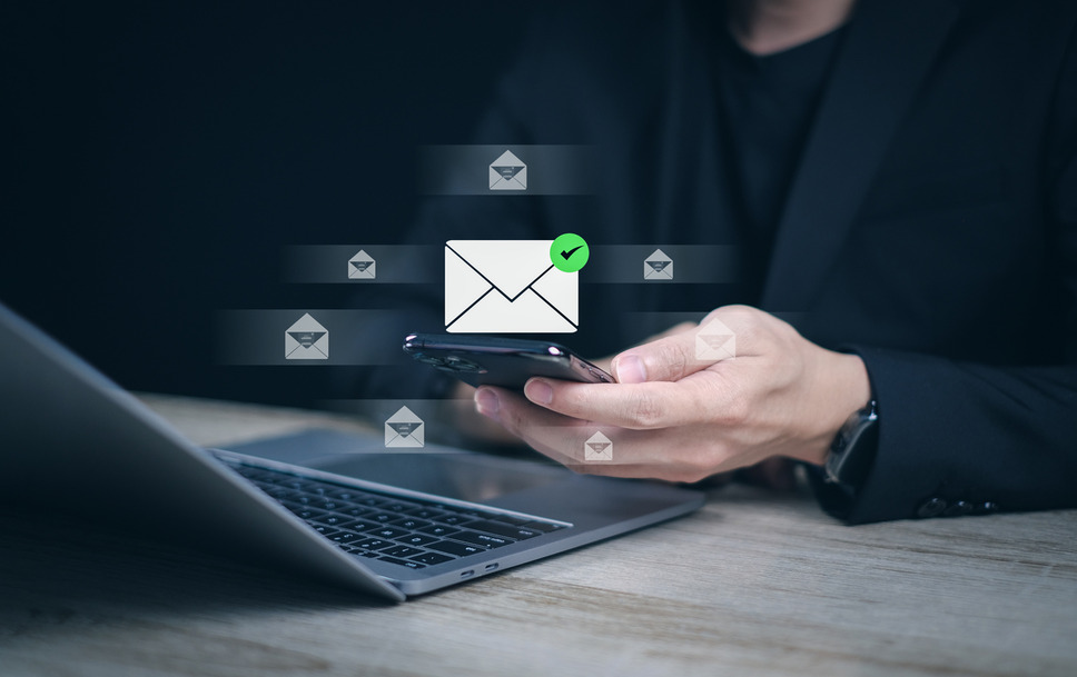 Person using smartphone to open and read emails, indicating business success with converting email subject lines