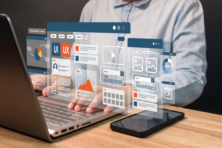 Professional working on a laptop with icons symbolizing successful user experience and interface design for digital platforms