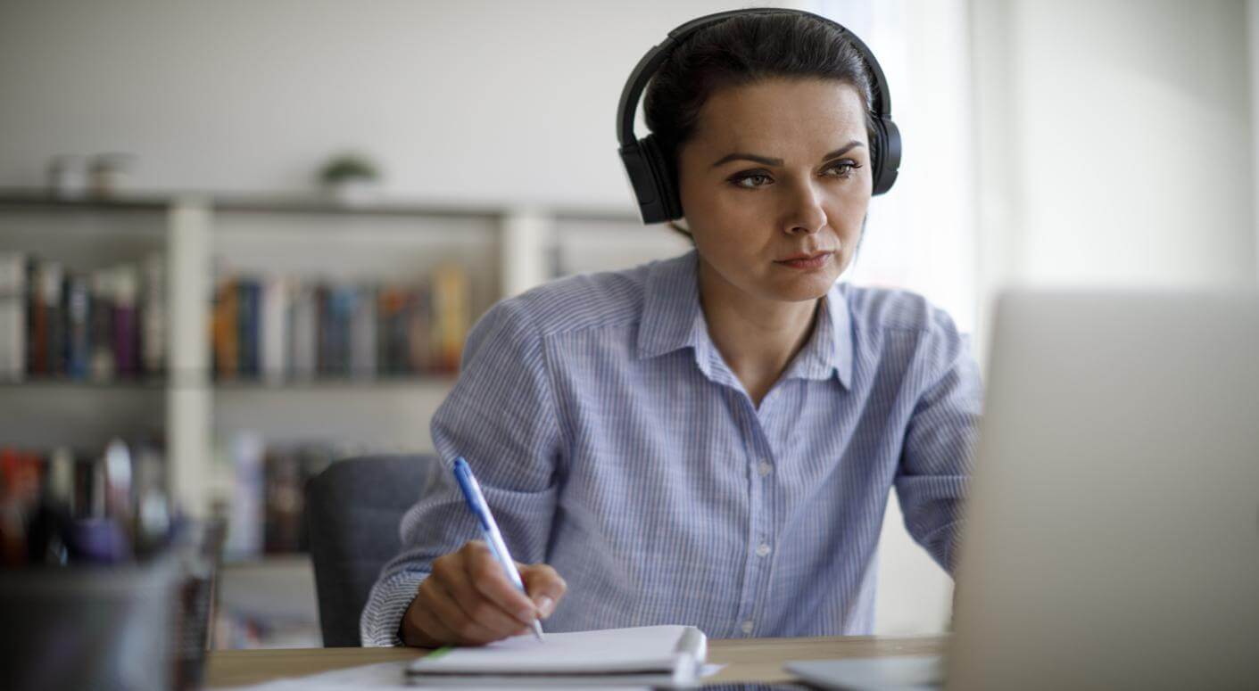 lady listening to computer and taking notes