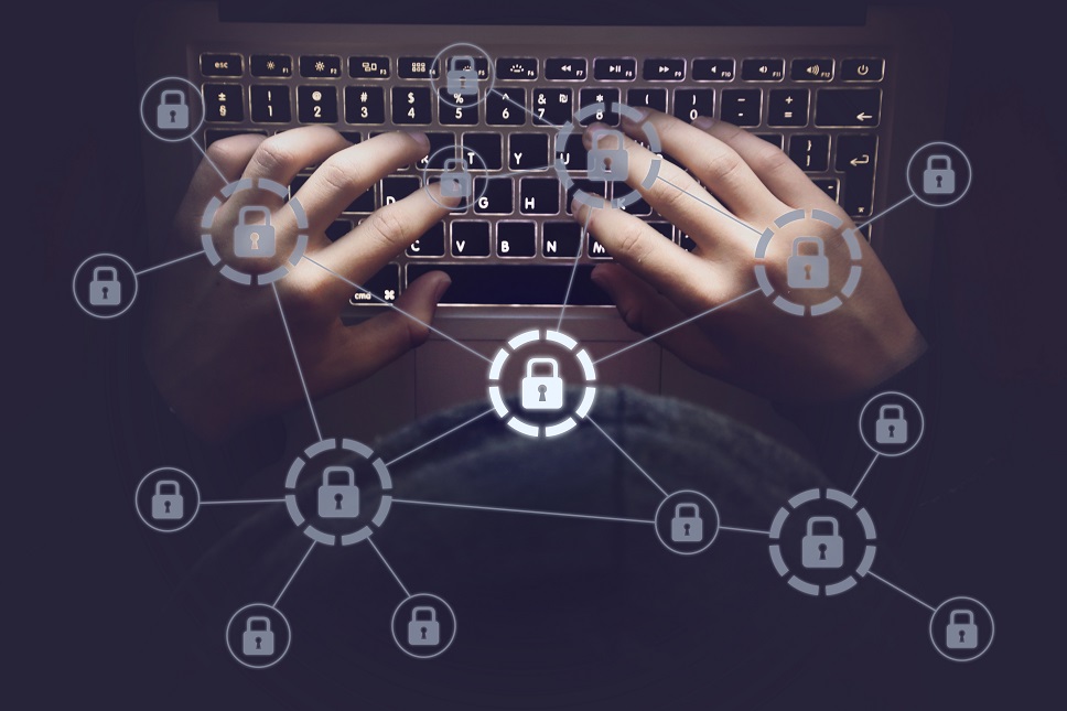 Hands typing on a laptop keyboard with virtual security padlock icons, representing network protection.