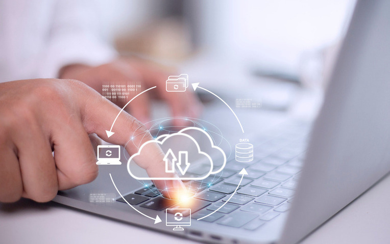 Professional interacting with IaaS cloud computing icons on a laptop, depicting business success with managed cloud services