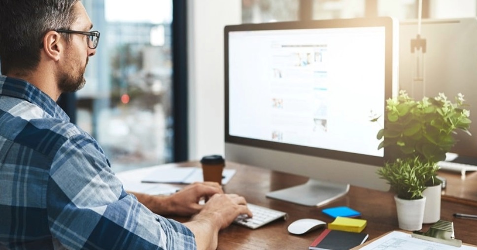 Person posting website content on a computer, showcasing success with Kentico digital agency to develop experience platform