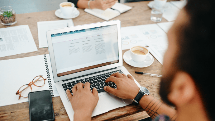 Marketer working on laptop, representing website copywriter services focused on strategy, creation, and digital engagement