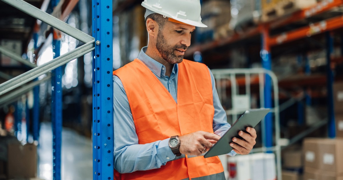 Worker using a tablet in a warehouse, showcasing integrated logistics, distribution, and ecommerce for manufacturer websites