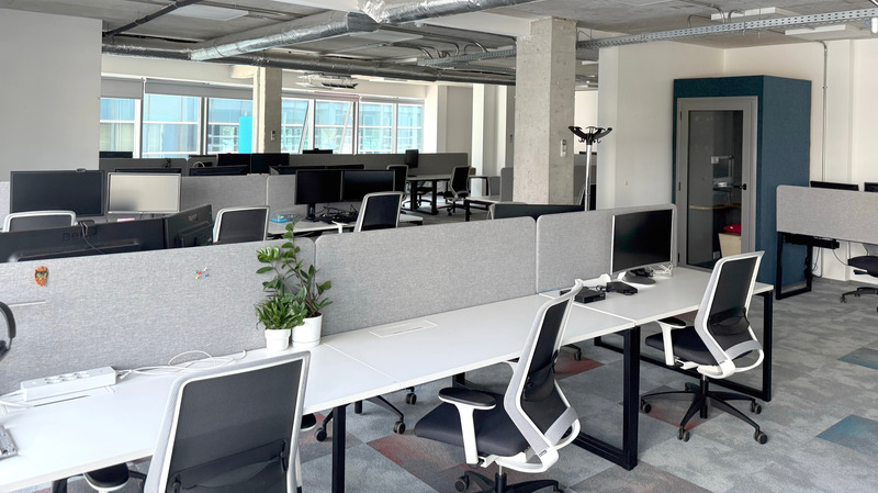 Spacious modern office with rows of desks, computers, and ergonomic chairs, displaying Americaneagle.com's Sofia office