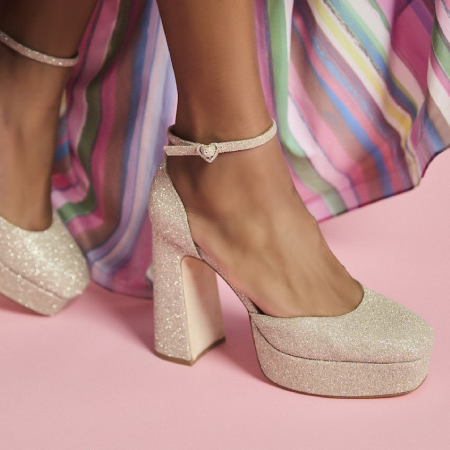 Woman wearing Badgley Mischka glittery high heels, signifying business success with ecommerce web development agency services