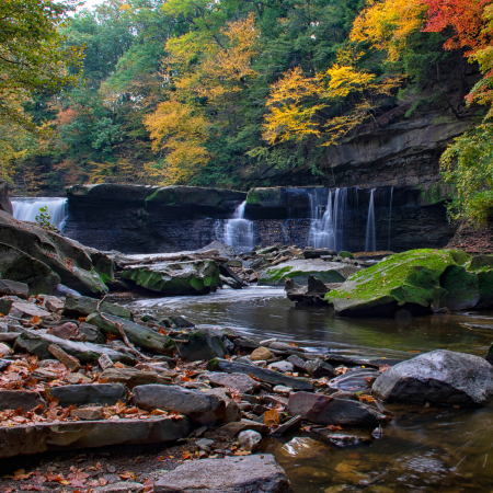 Autumn waterfall in forest, reflecting success with digital services for parks, civic engagement, and public outreach