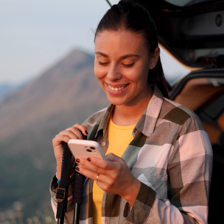 Person outdoors using mobile device for online banking, indicating success with digital marketing for credit union engagement