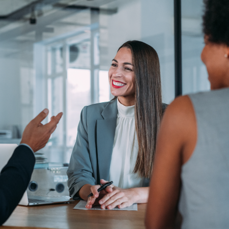 Smiling businesswoman in a meeting with colleagues at an office.