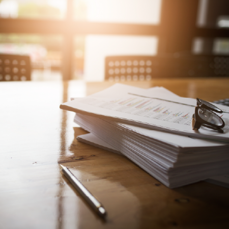 Stack of financial documents on a desk, indicating successful digital strategy and website development for financial services