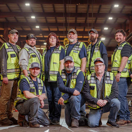 Workers inside a steel distribution facility, depicting success with digital strategy and B2B portal development services