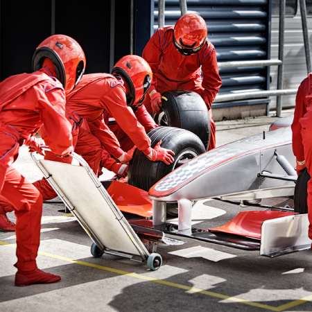 M1 Concourse pit crew servicing a race car, representing the motorsports brand’s success with an immersive digital experience