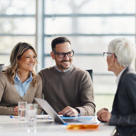 Couple meeting with an advisor with a laptop indicating success with digital marketing services for insurance