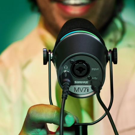 Person behind Shure microphone, representing manufacturer success with digital agency services