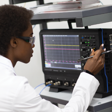 Technician adjusting controls on electronic test instrument showing success with digital marketing services for manufacturing