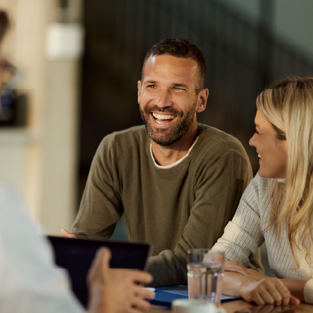 Couple discussing banking options with a financial advisor in a bank office, depicting success with digital agency services