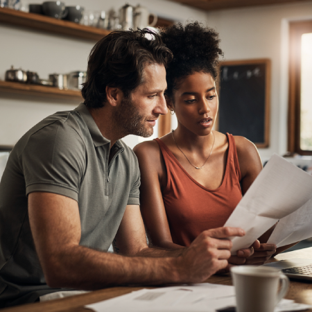Couple reviewing documents together at a table, signifying success with insurance website development agency services for RGA