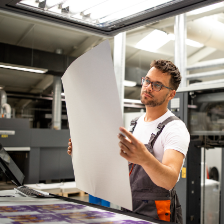 Skilled worker examining labels to print in facility, depicting success with digital agency services for manufacturers
