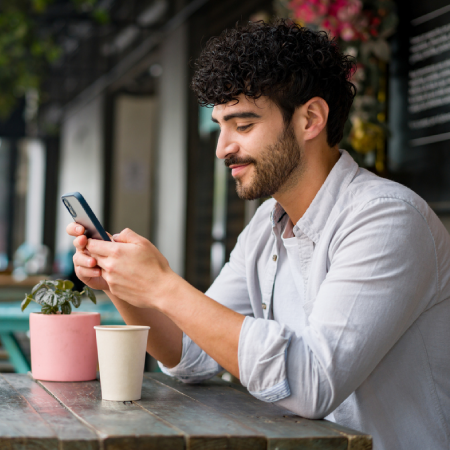 Man using a smartphone for mobile banking, representing customer engagement for credit unions with web design agency services
